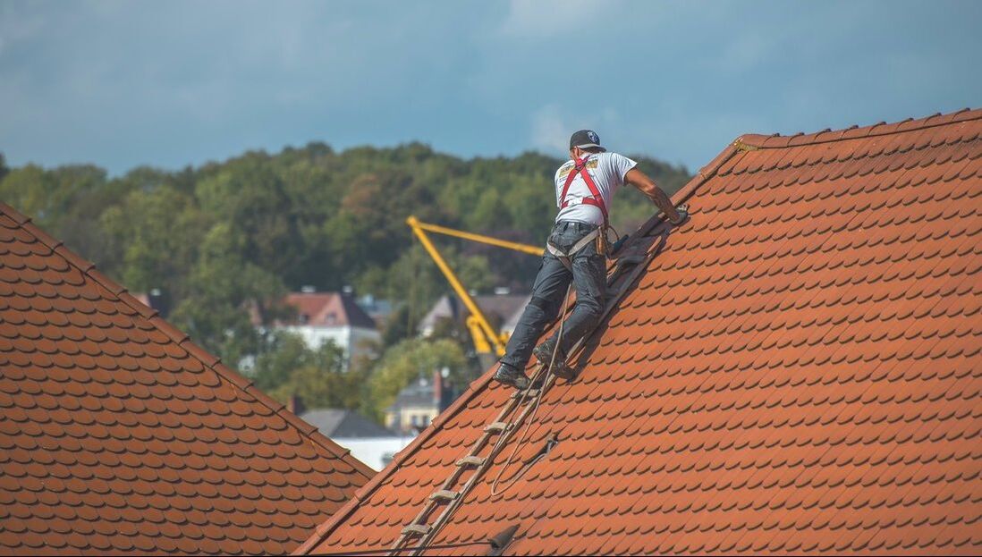 Man harnessed in to inspect a roof