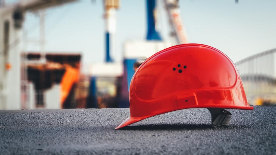 Construction site with focus on a red construction helmet