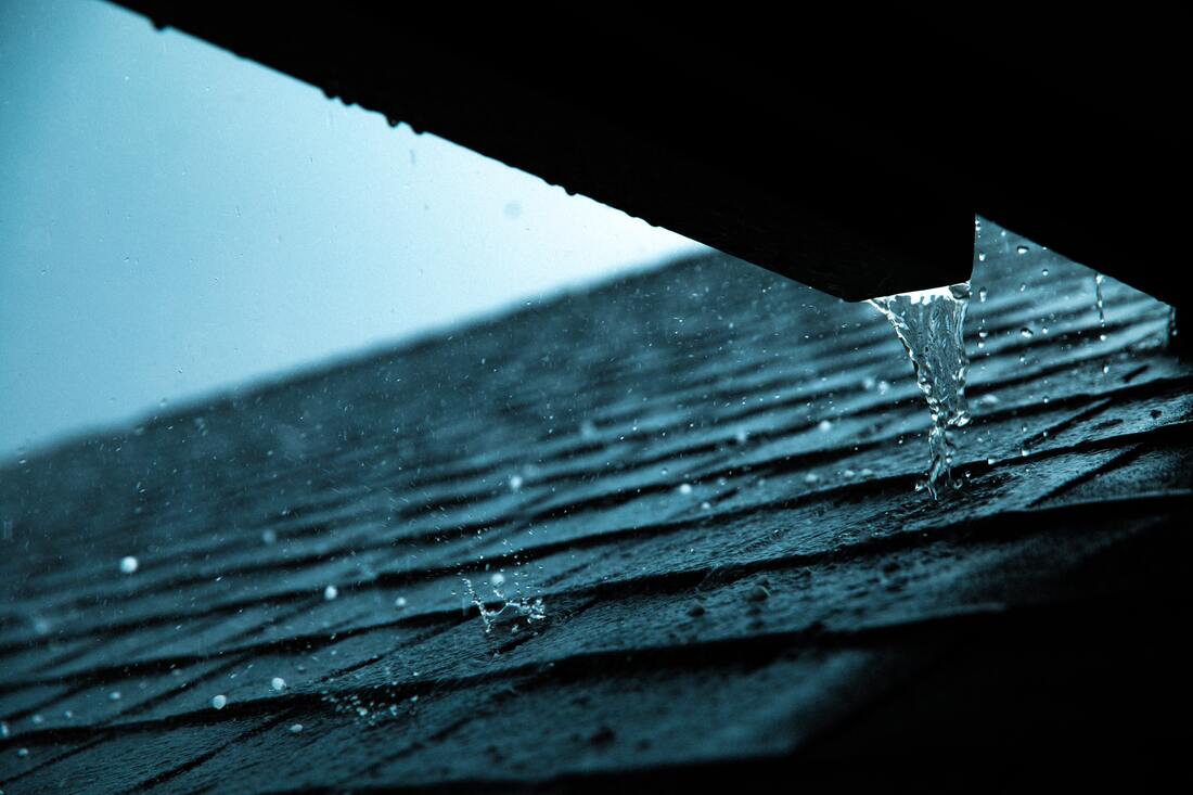 Water running down a roof with asphalt shingles